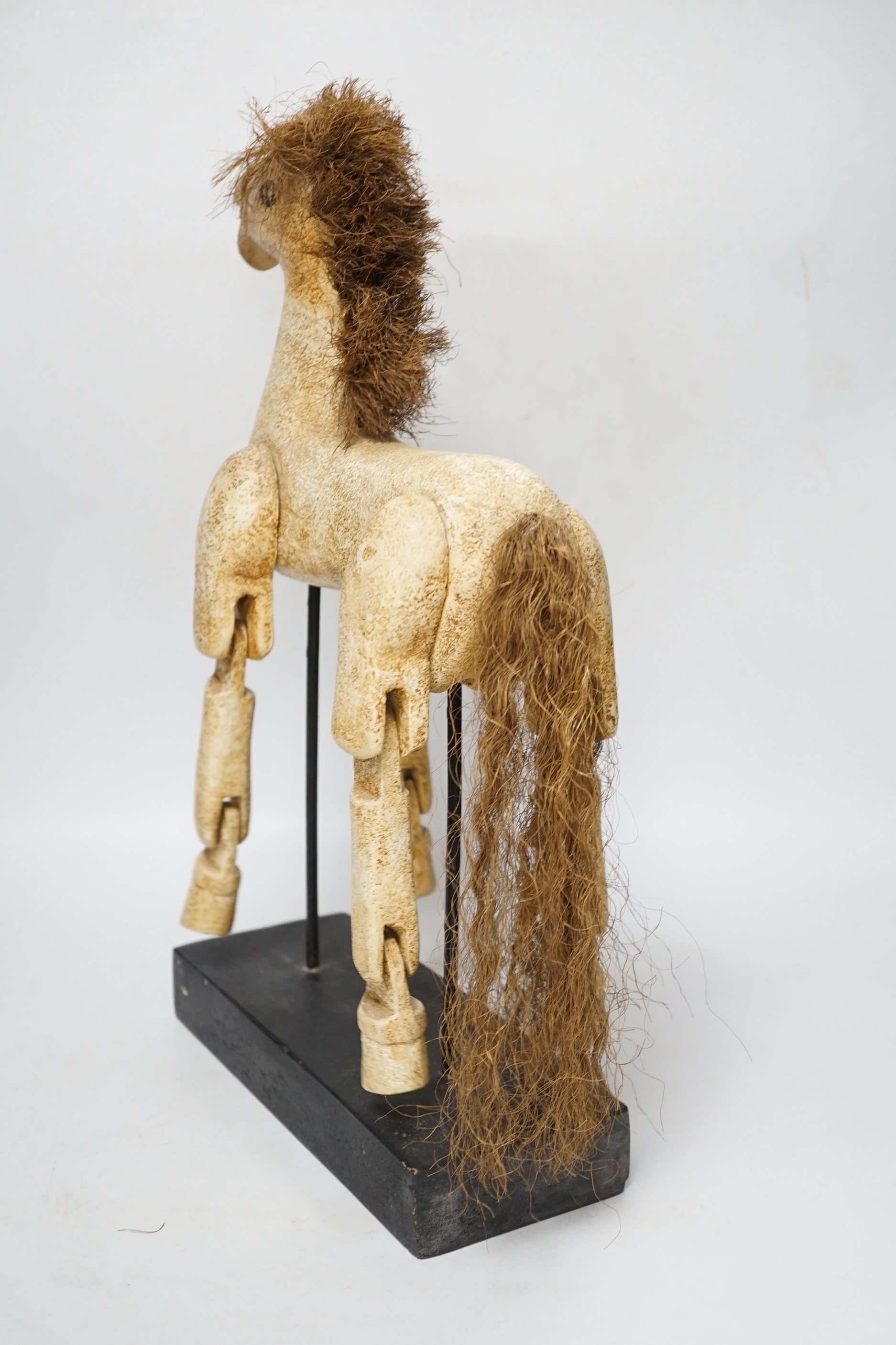 A painted, carved wood articulated model horse on stand, 42cm